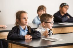 Academy members work at a desk and listen to instructions