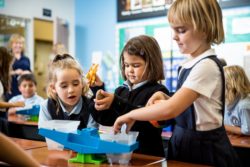 Elementary school aged students play with various educational toys