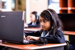 A student types into a modern computer at school