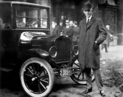 Henry Ford in front of an old style automobile