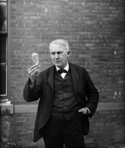 Edison examining a lightbulb