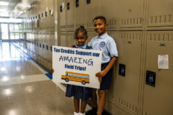 2 students holding a sign