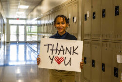 student holding a thank you sign